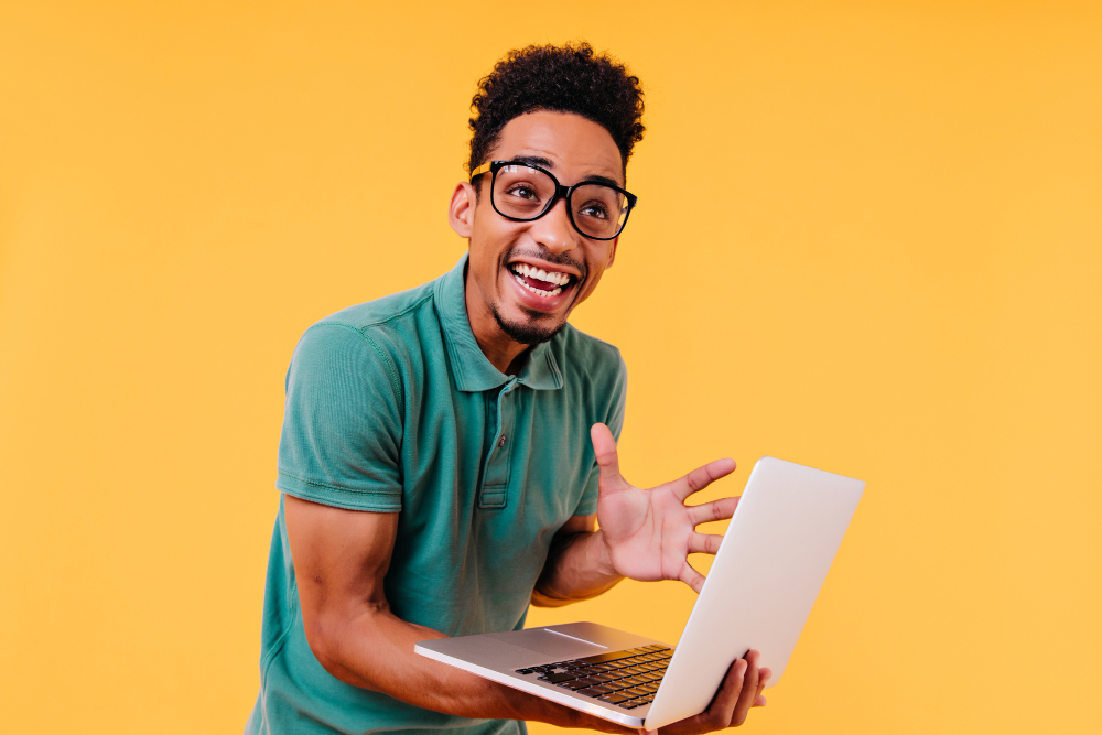 laughing-black-man-glasses-expressing-excitement-emotional-international-student-holding-computer